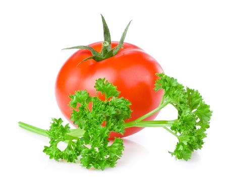 One fresh juicy tomato and a sprig of parsley isolated on white backgroundの写真素材