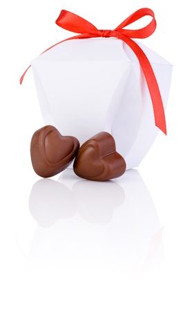 Two hearts chocolate and White gift box with a bow of red ribbon Isolated on white backgroundの写真素材