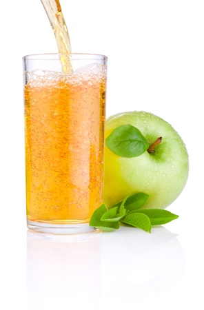 Pouring apple juice into a glass, green juicy apples with green leaf on white backgroundの写真素材