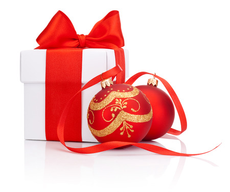 White gift box tied with Red ribbon and two decorations Christmas ball Isolated on white backgroundの写真素材