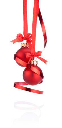 Two Red Christmas ball hanging with ribbon bow and curling paper Isolated on white backgroundの写真素材
