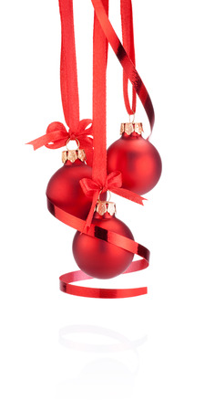 Three Red Christmas ball hanging with ribbon bow and curling paper Isolated on white backgroundの写真素材