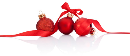 Three Red Christmas balls with ribbon bow Isolated on white backgroundの写真素材