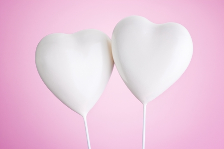 Two white hearts on a pink backgroundの写真素材
