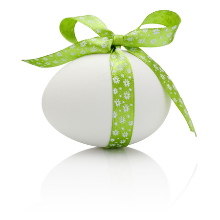 Easter egg with festive green bow isolated on white backgroundの写真素材