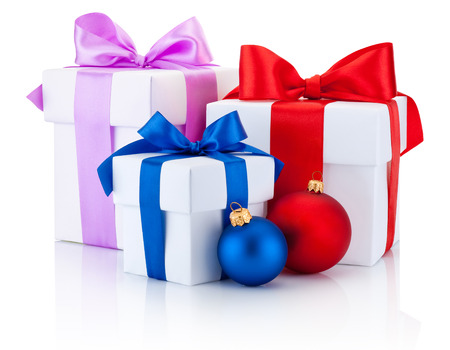 Three white boxes tied red, pink, blue ribbon bow and christmas balls Isolated on white backgroundの写真素材