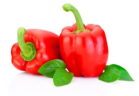 Two Red Peppers with green leaves isolated on white backgroundの写真素材