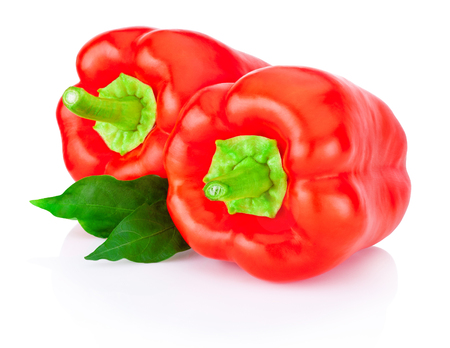 Two bell Red Peppers with green leaves isolated on white backgroundの写真素材