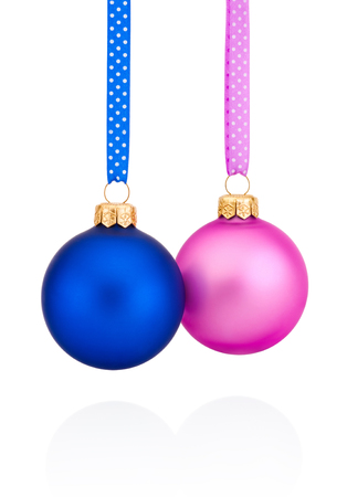 Blue and pink Christmas baubles hanging on ribbon Isolated on white backgroundの写真素材