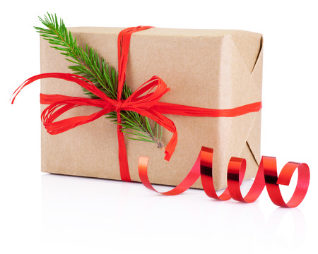 Christmas gift in craft paper tied red braid and pine tree branch Isolated on white backgroundの写真素材