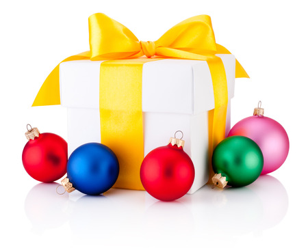 White gift box tied yellow ribbon and colored Christmas baubles Isolated on white backgroundの写真素材