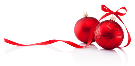Two red Christmas decoration baubles with ribbon bow isolated on white backgroundの写真素材