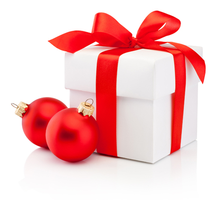 White gift box tied red ribbon bow and two Christmas bauble Isolated on white backgroundの写真素材