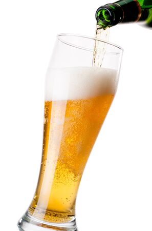 Pouring beer from bottle to glass on a white backgroundの写真素材