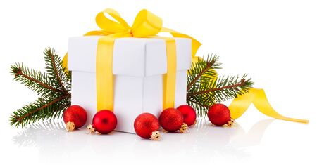 White gift box tied yellow ribbon bow, Christmas baubles and fir tree branch Isolated on a white backgroundの写真素材