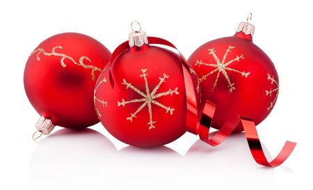 Three red Christmas decoration baubles and curling paper Isolated on a white backgroundの写真素材