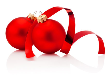 Two red Christmas baubles and curling paper Isolated on a white backgroundの写真素材