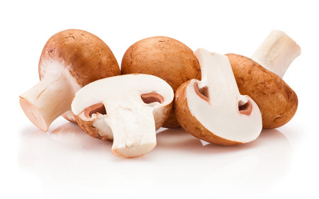 Fresh whole and sliced champignon mushrooms isolated on a white backgroundの写真素材