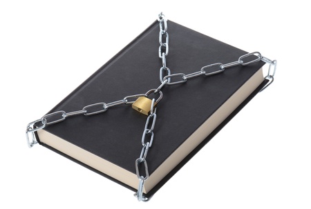 concept of security a book padlocked with chains isolated on whiteの写真素材