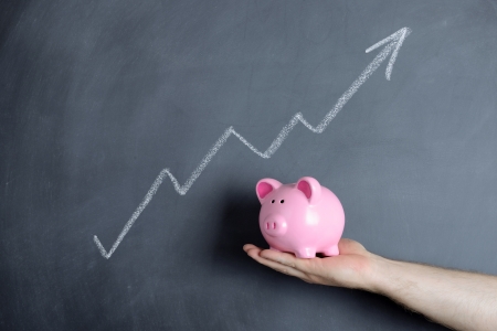 Piggy bank over chalkboard of growth chartの写真素材