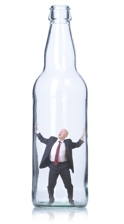 businessman trapped in a clear glass bottle isolated on whiteの写真素材