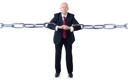 A powerfull businessman holding chains together isolated on a white backgroundの写真素材