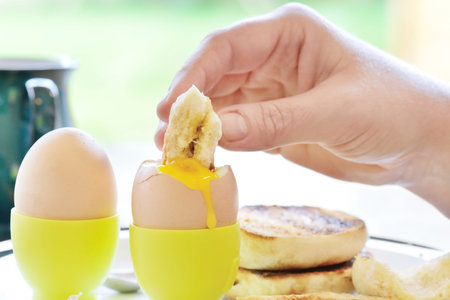 a healthy breakfast dipping into an egg