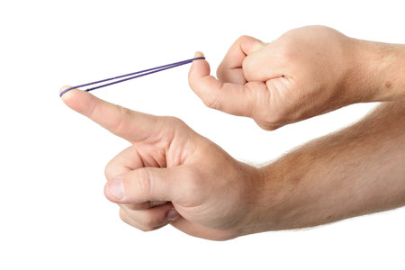 Hands stretching a rubber band as to shoot it, isolated on a white background