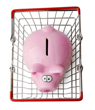 Piggy bank in a shopping basket viewed from above isolated on a white backgroundの写真素材