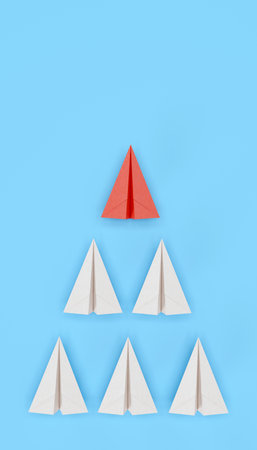 Red paper plane as leader of others on a  blue background withの写真素材