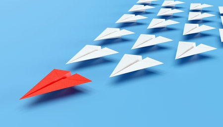 Red paper plane as leader of others on a plain blue background