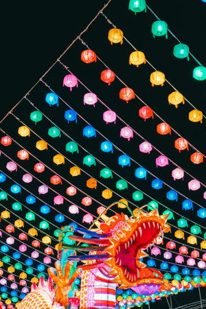Vibrant Multicolored Lanterns and a 3D Dragon Structure against the Night Skyの写真素材