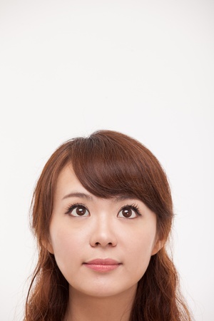 Looking up space Asian woman isolated on white background の写真素材