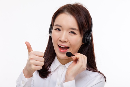 Smiling call center operator business woman show thumbs isolated on white background  の写真素材