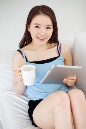 Young Asian woman using a pad PC with coffeeの写真素材