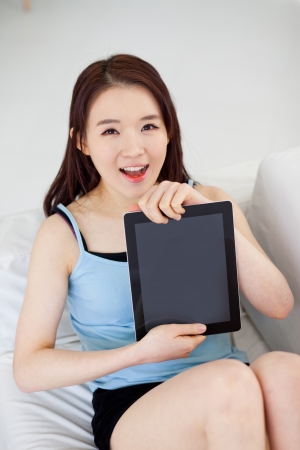 Young Asian woman using a pad PC and showing screenの写真素材