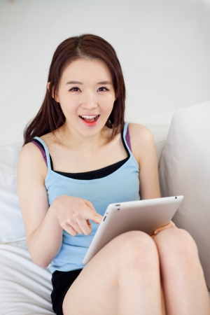 Young Asian woman using a pad PC in the sofaの写真素材