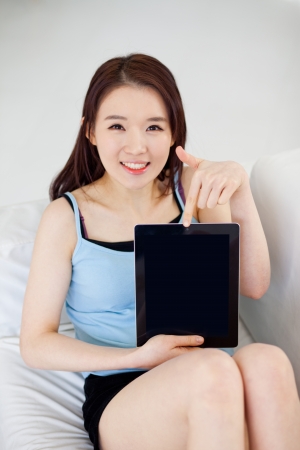 Young Asian woman using a pad PC and showing screenの写真素材