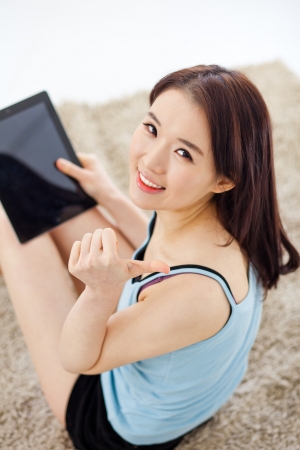 
Young Asian woman using a pad PC in the home and show thumb.の写真素材