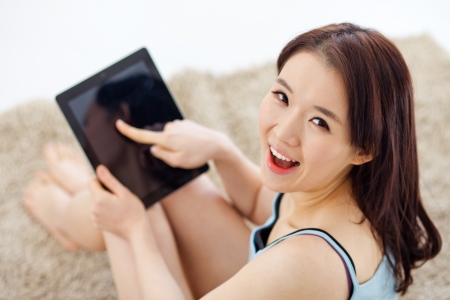 Asian woman using a pad PC on the floor.の写真素材