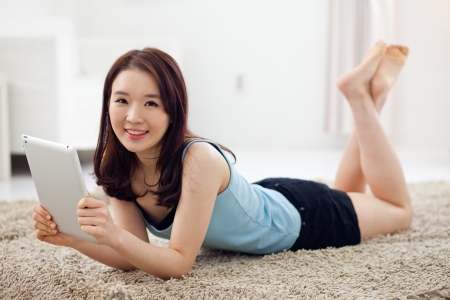 Young Asian woman using a pad PC in the home. の写真素材