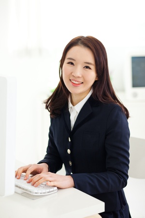Happy Asian young woman using computer in home background. の写真素材