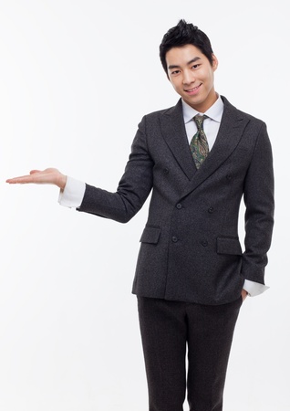Young Asian business man showing something isolated on white background. の写真素材