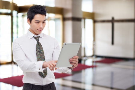 Young Asian business man using a pad PC in business background. の写真素材