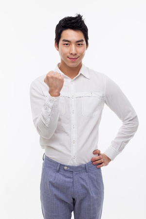 Young Asian man showing fist and happy sign isolated on white background. の写真素材