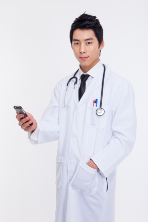 Young Asian doctor using smar phone isolated on white background.の写真素材