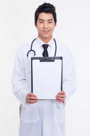 Young Asian doctor showing empty notebook isolated on white background の写真素材