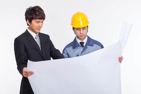 Asian business man and engineer having a blueprint isolated on white.の写真素材