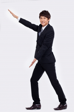 Young Asian business man showing something isolated on white background. の写真素材