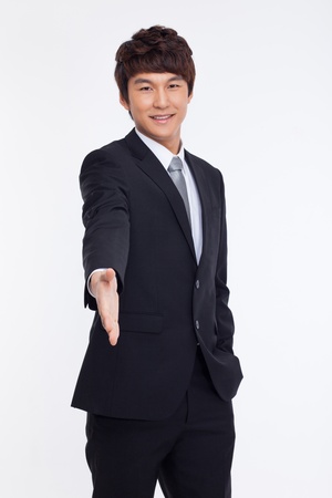 Young business man extending hand to shake isolated on white background. の写真素材